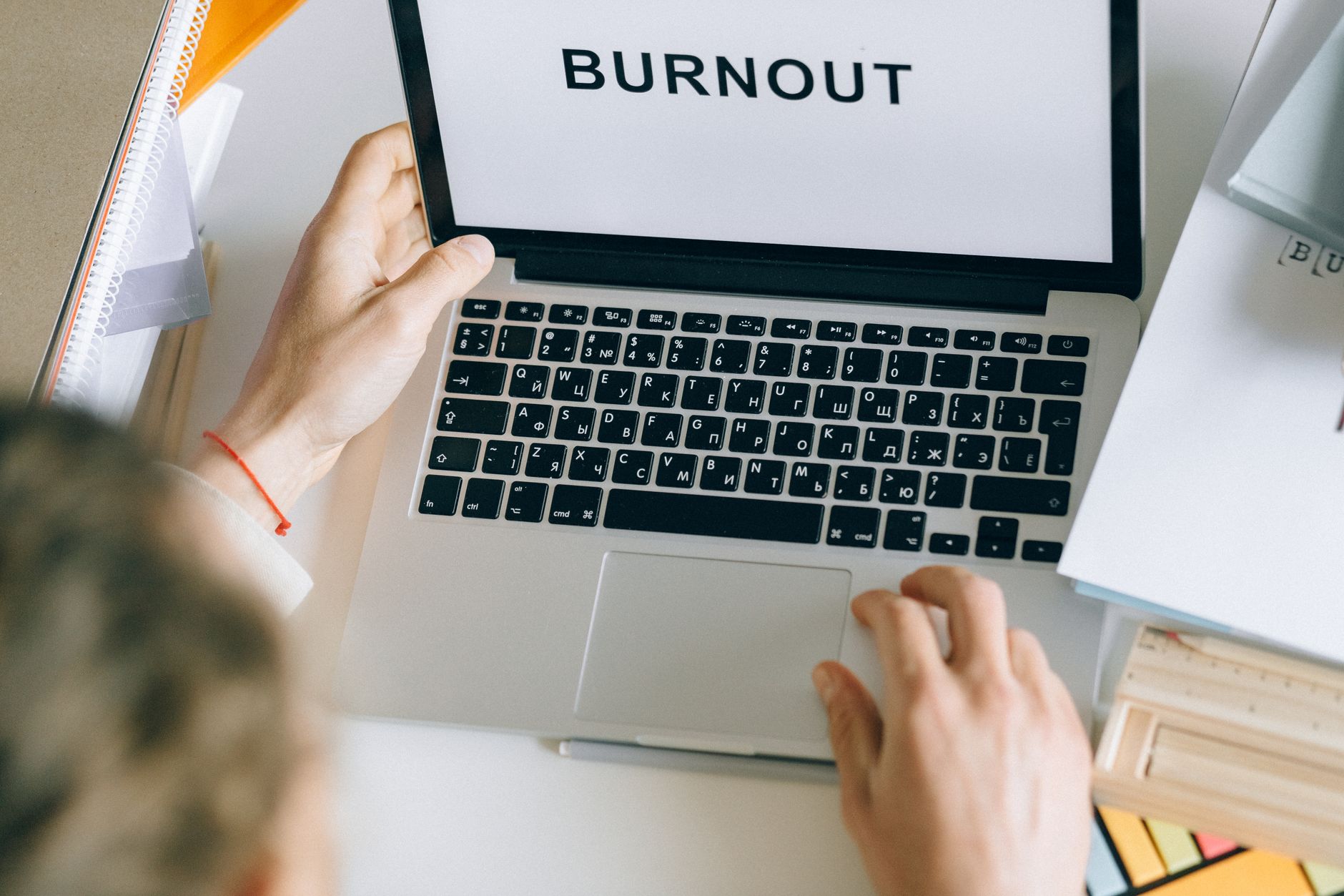 Ilustrasi pria stres di meja kerja untuk menggambarkan gejala burnout